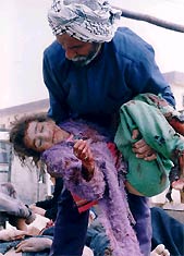 Un iraquí sostiene a una niña herida en Basora (AP)